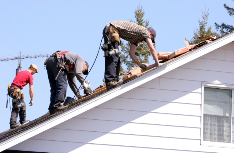 Professional roofers working on a residential roof